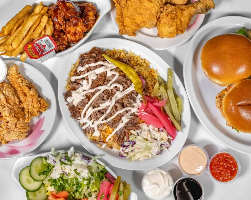 A spread of AL CHICK fried chicken, shawarma, sides and sandwiches